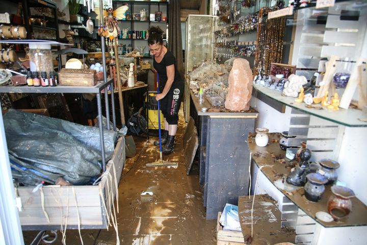 Une commerçante nettoie son magasin, à Ajaccio (Corse-du-Sud), après les intempéries, le 12 juin 2020. (PASCAL POCHARD-CASABIANCA / AFP)
