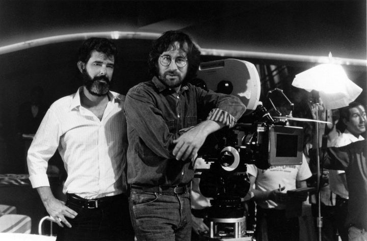 Le producteur George Lucas (à gauche) et le réalisateur Steven Spielberg sur le tournage d'"Indiana Jones et le Temple maudit", en 1984. (LUCASFILM / COLLECTION CHRISTOPHEL VIA AFP)