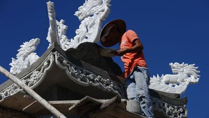 Dans ce concours de création mortuaire gigantesque, on utilise du marbre et des émaux. De nouveaux chantiers continuent d'être lancés, tandis que l'entretien des monuments atteint ici son apogée. Rénover sans relâche les tombeaux, «c'est une façon pour les enfants de montrer leur respect envers les ancêtres. Cela restera là pour l'éternité», selon un pêcheur de An Bang. (HOANG DINH NAM / AFP)