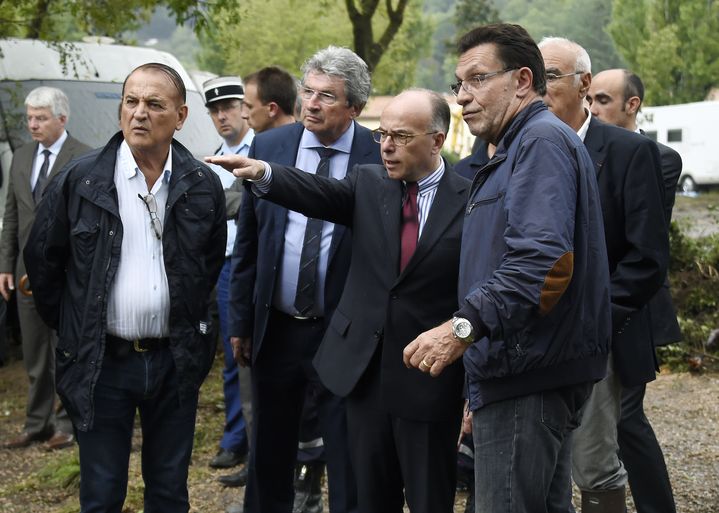 Le maire de&nbsp;Lamalou-les-Bains, Philippe Tailland (&agrave; droite), aux c&ocirc;t&eacute;s du ministre de l'Int&eacute;rieur, Bernard Cazeneuve (au centre), dans le camping frapp&eacute; par une crue exceptionnelle, le 18 septembre 2014. (PASCAL GUYOT / AFP)