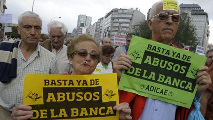 Des militants d'une association de consommateurs de banques manifestent contre les abus bancaires le 2 juin 2012 &agrave; la Corogne (Espagne). (MIGUEL RIOPA / AFP)