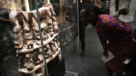 Un visiteur admirant une pièce&nbsp;durant l'exposition "Art du Bénin d'hier et d'aujourd'hui, de la restitution à la révélation", en février 2022. (PIUS UTOMI EKPEI / AFP)