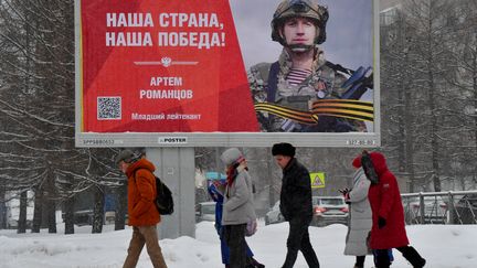 People walk past a sign with the inscription "Our country, our victory" in Saint Petersburg on January 16, 2024. (OLGA MALTSEVA / AFP)