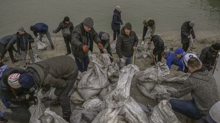 Des habitants remplissent des sacs de sable pour former des barricades le long des plages d'Odessa (Ukraine), face à la mer Noire, lundi 7 mars 2022.
 (AFP)