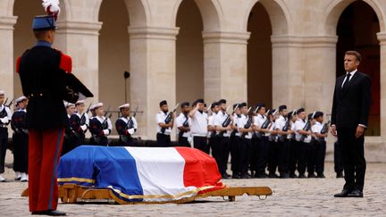 Le président de la République Emmanuel Macron, devant le cercueil de Jean-Louis Georgelin, drapé du drapeau français, le 25 août 2023, à Paris. (CHRISTIAN HARTMANN / AFP)