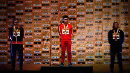 Benjamin Compaoré (à droite) sur le podium des championnats du monde en salle de triple saut derrière le Chinois Dong Bin et l'Allemand Max Hess.  (CHRISTIAN PETERSEN / GETTY IMAGES NORTH AMERICA)