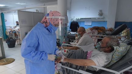 Un médecin tunisien&nbsp;apporte les&nbsp;premiers soins aux patients du Covid-19, dans un hôpital de Tunis, le 16 juillet 2021.&nbsp; (FETHI BELAID / AFP)