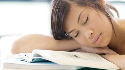 Jeune femme endormie sur un livre. Photo d'illustration. (ERIC AUDRAS / MAXPPP)