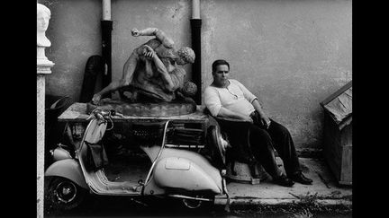 William Klein a révolutionné la photo dans les années 1950 avec ses vues de New York au grand angle, en gros plan, sans souci du bougé. En 1956, il remet ça à Rome. Ses familles entassées sur une vespa ou son gardien des accessoires à Cinecittà sont drôles. Son regard sur les Romains est un peu cliché. Le plus beau, ce sont les personnages flous, fantomatiques, qui s’effacent devant les monuments.
 (William Klein)