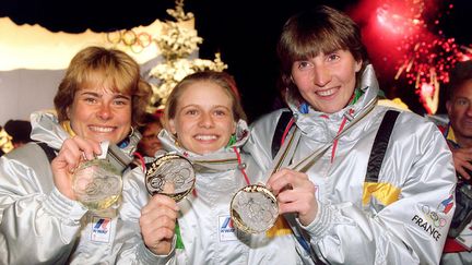 Anne Briand, Corinne Niogret et Véronique Claudel avec leur médaille d'or du relais féminin sur le podium aux Saisies, le 14 février 1992. (GABRIEL BOUYS / AFP)