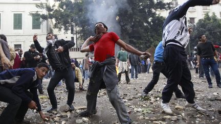 Des manifestant jettent des pierre aux soldats, le 16 d&eacute;cembre 2011 au Caire (Egypte). (AMR ABDALLAH DALSH / REUTERS)