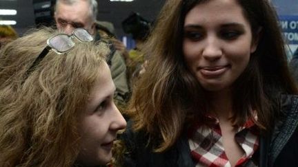 Maria Alyokhina et Nadezhda Tolokonnikova, deux des Pussy Riot, se retrouvent à l'aéroport de la ville sibérienne de Krasnoïarsk, au lendemain de leur libération, le 23 décembre 2013. (AFP PHOTO / VASILY MAXIMOV)