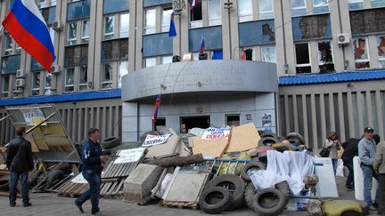 Des s&eacute;paratistes Pro-Russes montent la garde devant le si&egrave;ge des forces de s&eacute;curit&eacute; &agrave;&nbsp;Lougansk, dans l'est de l'Ukraine, le 9 avril 2014. (YURI STRELTSOV / RIA NOVOSTI / AFP)