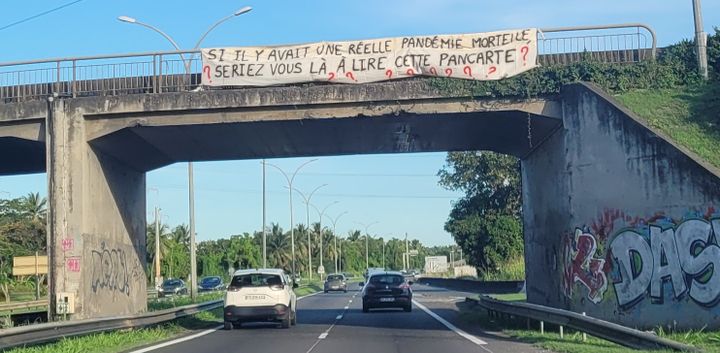 Une banderole sur la route de Pointe-à-Pitre depuis l'ouest de la Guadeloupe, le 24 novembre 2021.&nbsp; (FABIEN MAGNENOU / FRANCEINFO)