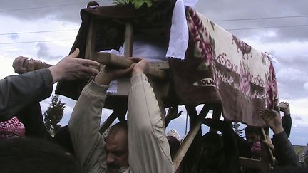 Des habitants de Maarat Al-Masrin, dans la province d'Idleb (Syrie), enterrent une victime des bombardements, le 14 mars 2012.&nbsp; (REUTERS)