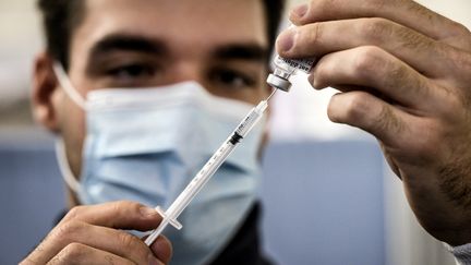 Un personnel de santé préparant une dose de vaccin anti-Covid-19 dans un centre de vaccination de Lyon. (JEFF PACHOUD / AFP)