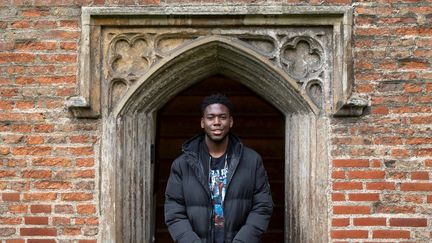 L'étudiant Matthew Omoefe Offeh pose devant le portail de l'université de Cambridge (octobre 2020).&nbsp; (JUSTIN TALLIS / AFP)