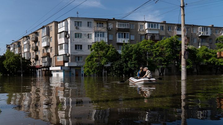 Des habitants de Kherson fuient les inondations lors d'une évacuation, le 7 juin 2023. (ALEKSEY FILIPPOV / AFP)