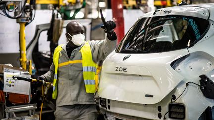 Un ouvrier travaille sur une voiture électrique Zoé, dans l'usine Renault de Flins-sur-Seine (Yvelines). (MARTIN BUREAU / AFP)