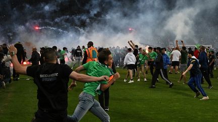 Des supporters de Saint-Etienne envahissent le terrain, à la fin du match de barrage&nbsp;perdu contre Auxerre, au stade Geoffroy-Guichard de Saint-Etienne, le 29 mai 2022. (JEAN-PHILIPPE KSIAZEK / AFP)