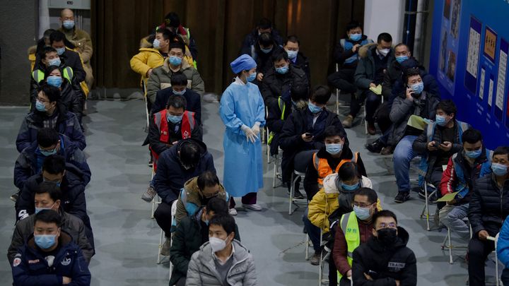 Des habitants de Pékin attendent sous surveillance après avoir reçu un vaccin contre le Covid-19, le 15 janvier 2021, peu après l'ouverture de la vaccination à tous les Chinois. (NOEL CELIS / AFP)