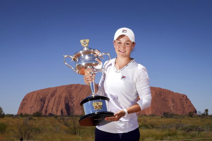 Ashleigh Barty pose avec son trophée de l'Open d'Australie devant le mythique Uluru, symbole de l'Australie, le 28 février 2022. (SCOTT BARBOUR / TENNIS AUSTRALIA / AFP)