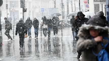 Des passants marchent sous la neige lors d'une vague de froid à Paris, le 5 février 2018. (JULIEN MATTIA / AFP)