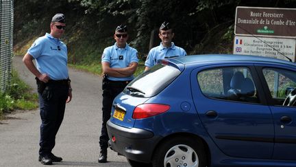 Des gendarmes gardent l'acc&egrave;s au parking forestier o&ugrave; quatre personnes ont &eacute;t&eacute; tu&eacute;es, &agrave; Chevaline (Haute-Savoie), le 6 septembre 2012. (JEAN-PIERRE CLATOT / AFP)