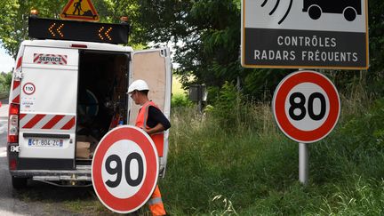 Un employé remplace un panneau de limitation de vitesse à Grenade (Haute-Garonne), le 28 juin 2018 (PASCAL PAVANI / AFP)