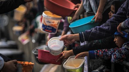 Des Palestiniens déplacés attendent de recevoir de la nourriture distribuée à Rafah, dans le sud de la bande de Gaza, le 24 février 2024. (YASSER QUDIHE / MIDDLE EAST IMAGES / AFP)