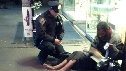 Une passante a photographi&eacute;, le 14 novembre 2012 &agrave; New York, un policier apportant des bottes &agrave; un SDF. Post&eacute; sur la page Facebook de la police new-yorkaise, le clich&eacute; a fait le tour des Etats-Unis. (JENNIFER FOSTER / SIPA / AP)