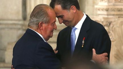 Le roi d'Espagne Juan Carlos (G) et son fils Felipe lors de sa c&eacute;r&eacute;monie d'adbication au Palais royal de Madrid (Espagne), le 18 juin 2014. ( JUAN MEDINA / REUTERS)