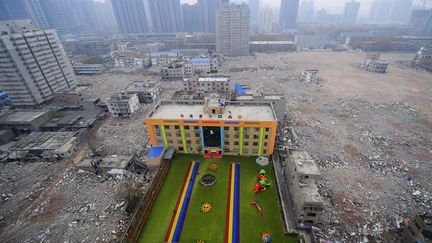 Un jardin d'enfants est situ&eacute; au milieu des d&eacute;combres d'un site r&eacute;cemment d&eacute;moli. Construit sans permis, cet espace devra prochainement fermer, Xi'An (Chine), le 8 d&eacute;cembre 2014. (REUTERS)