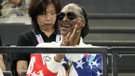 Snoop Dogg enchaîne. Quand il n'est pas aux commentaires des épreuves pour la chaîne américaine NBC, le rappeur américain assiste directement à la compétition, mélangé au public. Celui qui a porté la flamme olympique en Seine-Saint-Denis était, lui aussi, spectateur des qualifications féminines en gymnastique artistique à l'Arena Bercy le 28 juillet 2024. (CHARLIE RIEDEL / AP / SIPA)