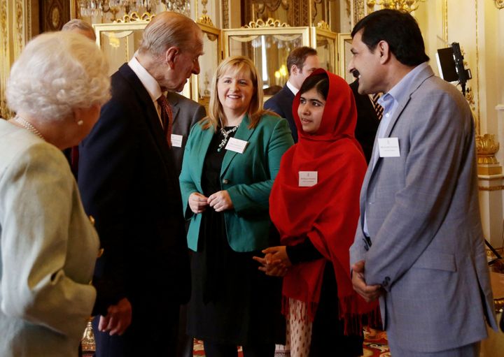 La reine Elizabeth II et le prince Philip parlant à Malala Yousafzai en présence du père de celle-ci, le 18 octobre 2013 au palais de Buckingham lors d'une réception.&nbsp;&nbsp; (YUI MOK / AFP)