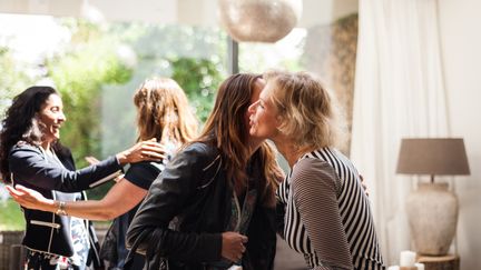 Des femmes se saluent en se faisant la bise. Photo d'illustration. (LUCY LAMBRIEX / DIGITAL VISION / GETTY IMAGES)