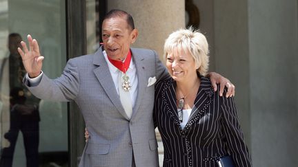 Henri Salvador et sa compagne, Catherine, à l'Élysée, le 25 juin 2004. (PATRICK KOVARIK / AFP)