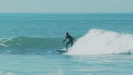 Un surfeur sur une planche en matériaux recyclés à Brétignolles-sur-Mer en Vendée.&nbsp; (FRANCEINFO)