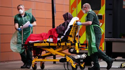 Des agents paramédicaux transportent une patiente vers l'hôpital royal de Londres qui s'attend à être surchargé par l'arrivée de malades du Covid-19. (DAVID CLIFF / NURPHOTO)