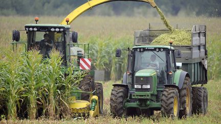 Une moissoneuse-batteuse et une remorque tirée par un tracteur dans la région de Rouperroux-le-Coquet (Sarthe). (JEAN-FRANCOIS MONIER / AFP)