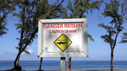 Un panneau d'avertissement sur la plage de l'Etang-Sale, à la Réunion, dans l'océan Indien. (RICHARD BOUHET / AFP)