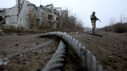 Un militaire ukrainien patrouille près&nbsp;d'une mine de charbon détruite, sur la ligne de front avec les séparatistes, dans la région de Donetsk, le 7 novembre 2019. (ANATOLII STEPANOV / AFP)