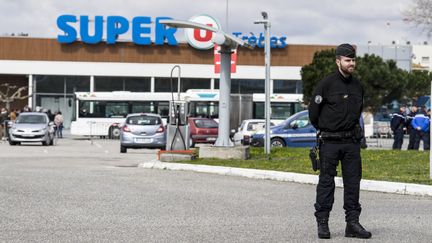 Un gendarme monte la garde devant le Super U de Trèbes (Aude), le 26 mars 2018. (IDRISS BIGOU-GILLES / HANS LUCAS / AFP)