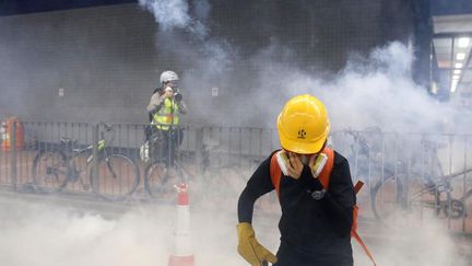 Un manifestant tente de se protéger après que la police a tiré des gaz lacrymogènes, le 10 août 2019, à Hong Kong. (THOMAS PETER / REUTERS)