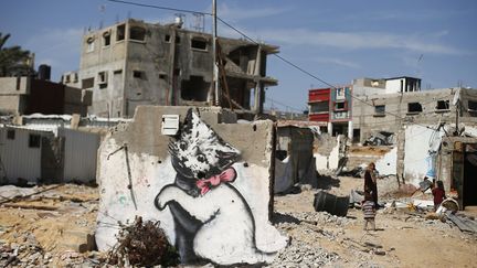 Une fresque murale attribu&eacute;e au street-artist Banksy sur ce qu'il reste d'une maison d&eacute;truite par les frappes isra&eacute;liennes &agrave; Gaza (Palestine), le 26 f&eacute;vrier 2015. (SUHAIB SALEM / REUTERS)