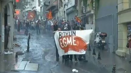 capture d'&eacute;cran, dans les rues proches de la place TAKSIM d'istanbul, des manifestants bloqu&eacute;s par les canons &agrave; eau des forces de l'odre - le 6 juillet 2013 (EVN / FRANCETV INFO)