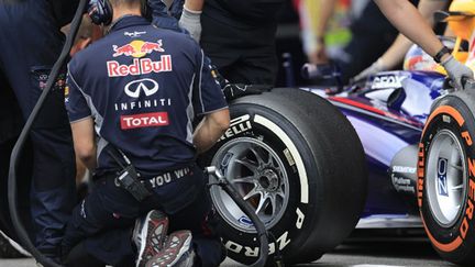 Un mécanicien change un pneu sur la Red Bull (ALEXANDER KLEIN / AFP)