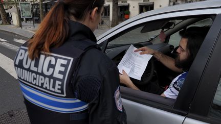 Un automobiliste présente son attestation à la police municipale, le 17 mars 2020, à Tours (Indre-et-Loire). (GUILLAUME SOUVANT / AFP)