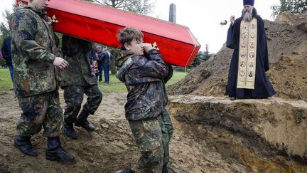 De jeunes bénévoles russes portent un cercueil contenant des restes de soldats soviétiques. Les dépouilles de 264 militaires ont ainsi été tranférés dans ce cimetière militaire. Cette cérémonie de réinhumation s'est déroulée le 16 septembre 2016, à environ 50 km au sud-est de Saint-Pétersbourg. C'est dans cette ville, devenue Leningrad en 1924 et qui a retrouvé son nom d'origine à la suite d'un référendum en 1991, que 200.000 soldats soviétiques sont tombés entre septembre 1941 et mai 1943. (AP Photo / Dmitri Lovetski - Octobre 2016)