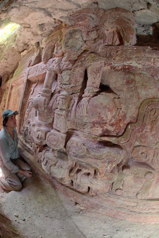 L'archéologue Francisco Estrada-Belli, au pied d'une des divinités représentées sur la frise guatéméltèque, vieille de 1413 années, découverte en juillet 2013 au Guatémala.
 (HOLMUL ARCHAEOLOGICAL PROJECT / AFP)